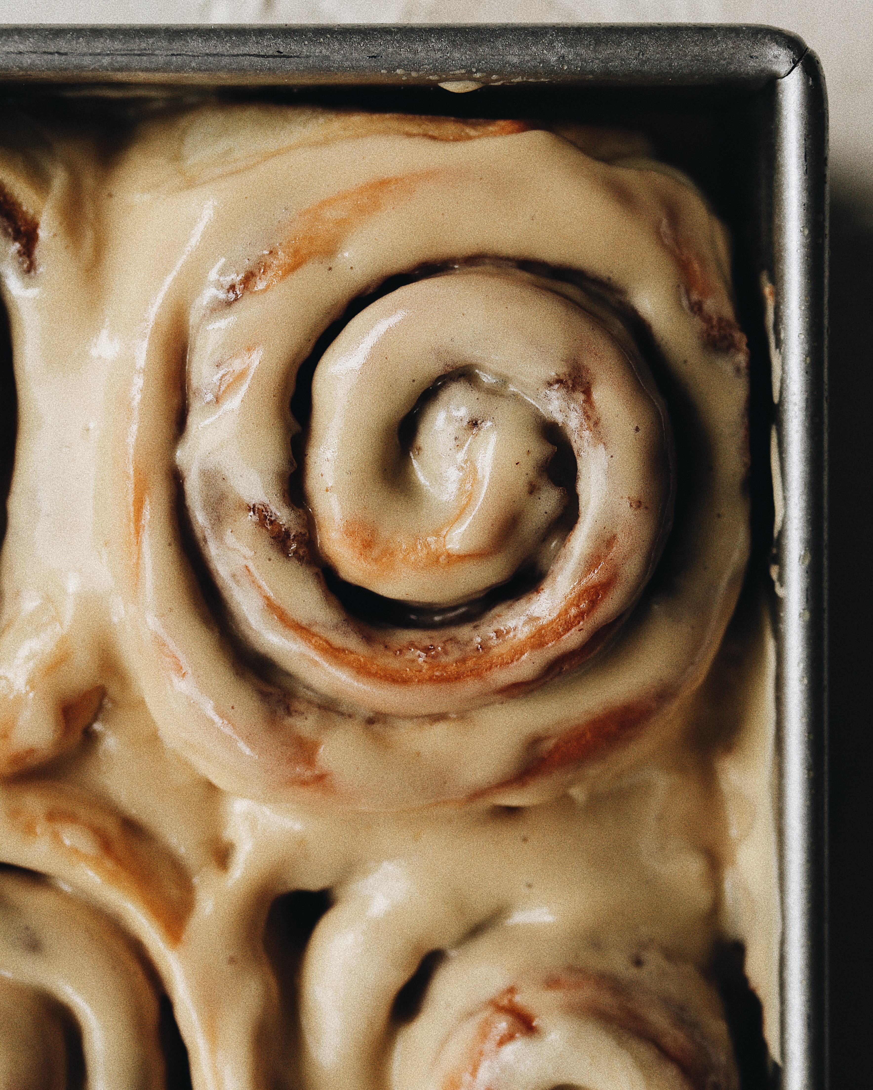 how prepared milk bread cinnamon rolls look after being frosted with coffee cream cheese frosting. 