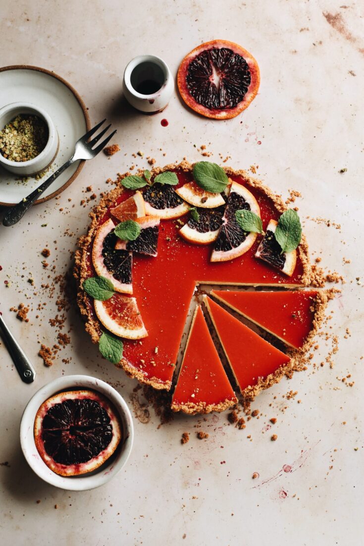 blood orange cheesecake tart, with slices cut out to show the inside texture